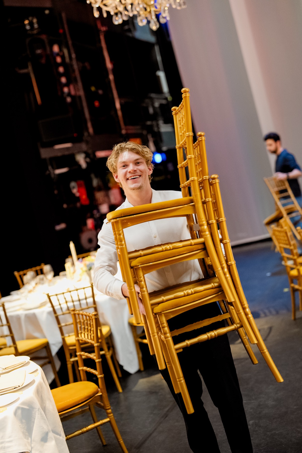 Build-up on stage: gold chairs being placed for the 175-guest dinner